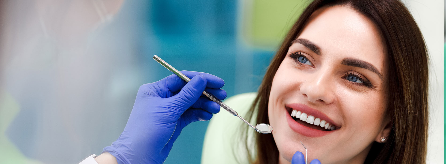 A well-lit reception area with a desk, computer monitor, and potted plant.