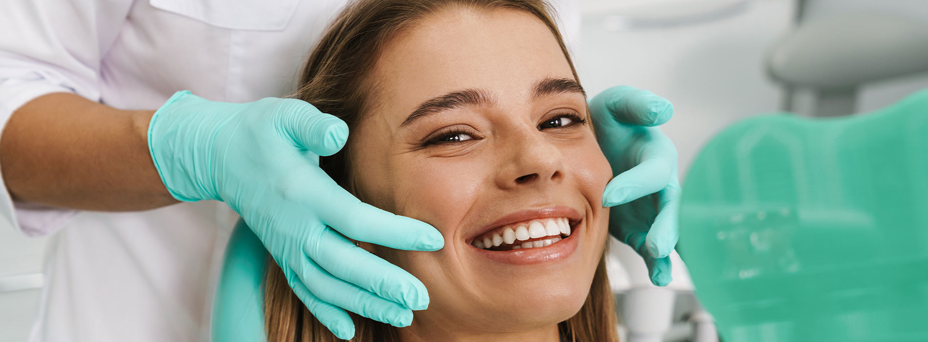 The image shows a modern dental clinic interior with various pieces of equipment, including a dental chair and an X-ray machine.